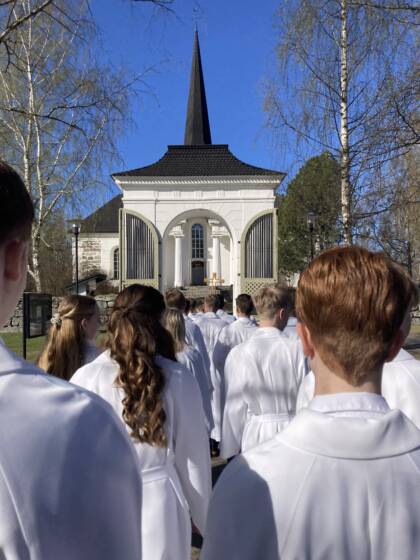 Konfirmander tågar mot porten till Pedersöre kyrka.