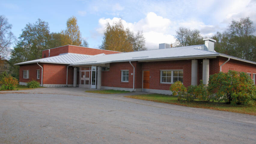 Bennäs kyrkhem med sin röda tegelfasad och ljusgråa tak.