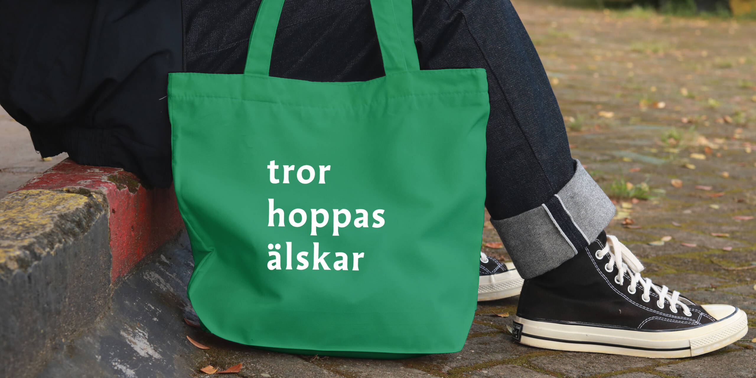grön tygkasse med texten tror hoppas älskar