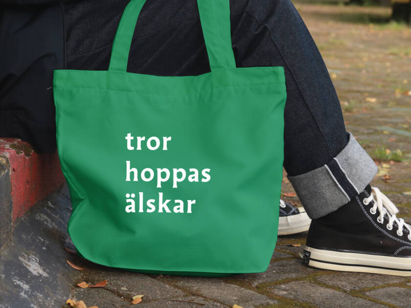 grön tygkasse med texten tror hoppas älskar