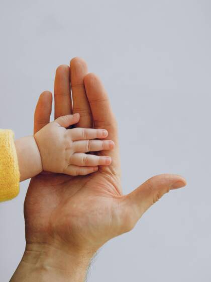 En vuxen hand och en liten barnhand
