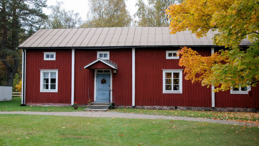 Bonäs församlingsstuga med sin röda fasad och blåa dörr.