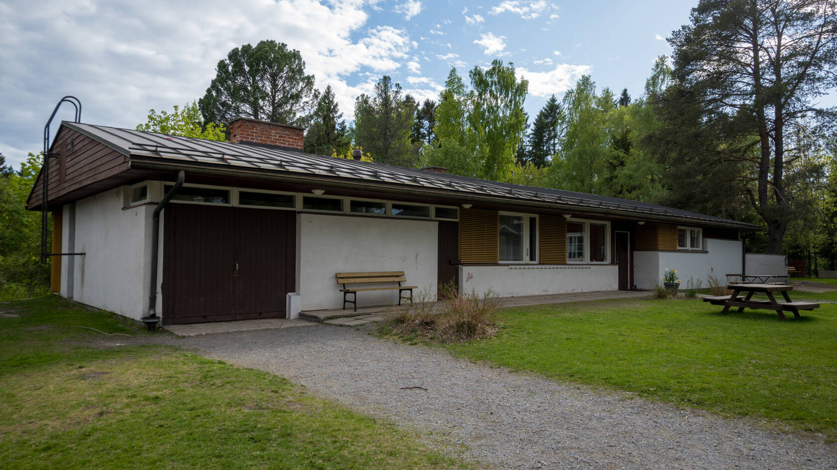 Bonäs prästgård är en låg byggnad med vit rappad fasad och brunt tak.