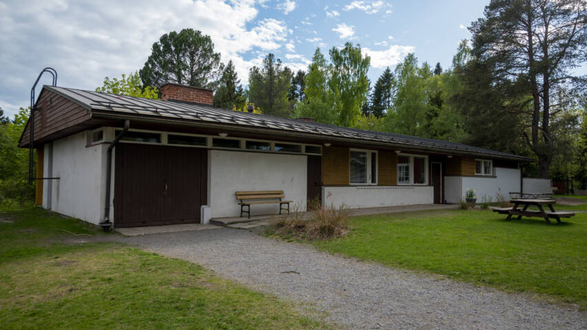 Bonäs prästgård är en låg byggnad med vit rappad fasad och brunt tak.