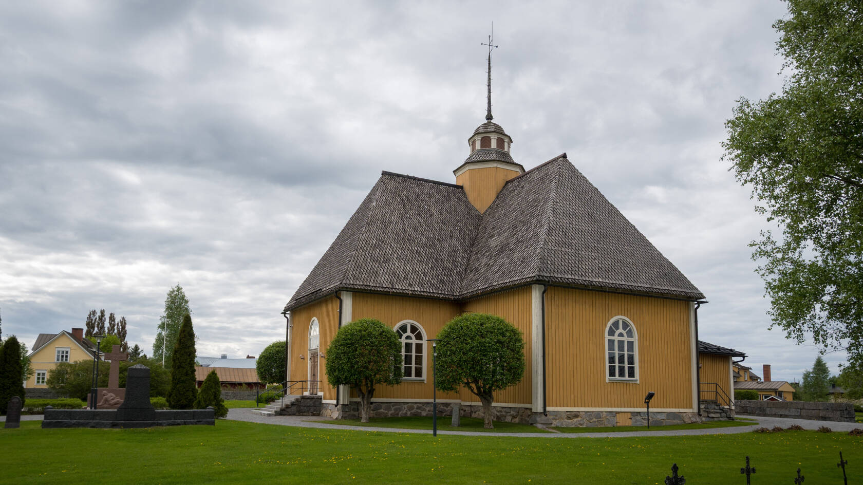 Esse kyrka med sin gula träfasad och mörka spåntak.