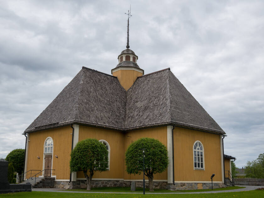 Esse kyrka med sin gula träfasad och mörka spåntak.