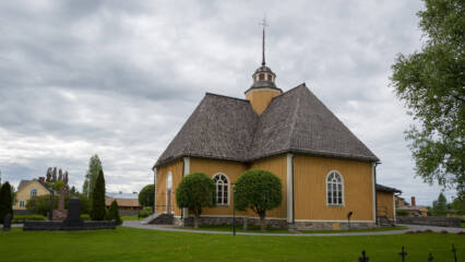 Esse kyrka med sin gula träfasad och mörka spåntak.