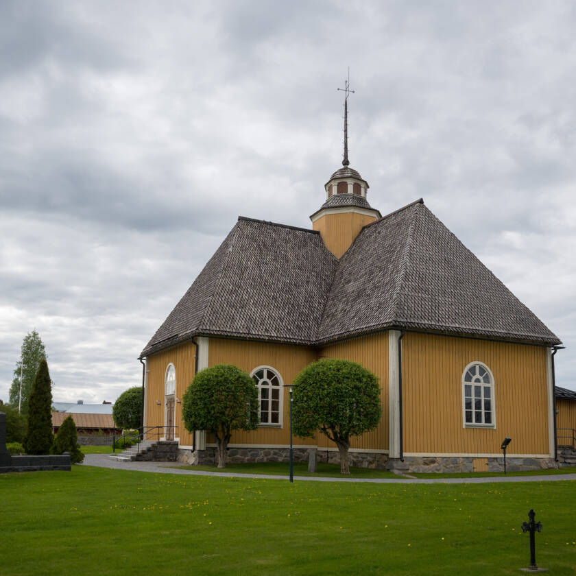 Esse kyrka med sin gula träfasad och mörka spåntak.